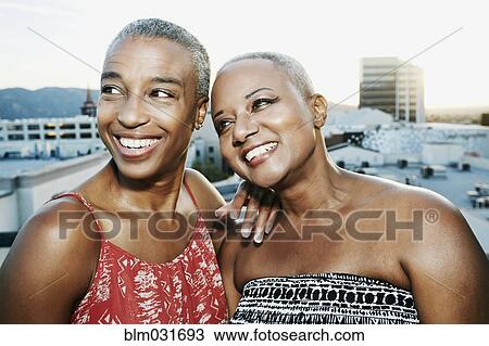 Black women smiling on urban rooftop View Large Photo Image Stock Image - Black women smiling on urban rooftop. Fotosearch