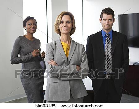 Stock Image - Business people smiling together in office. Fotosearch