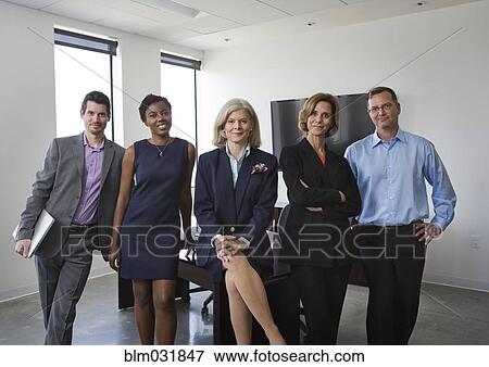 Business people smiling together in office View Large Photo Image Stock Photo - Business people smiling together in office. Fotosearch