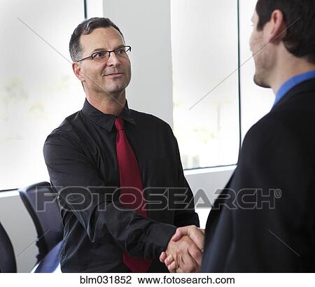 Businessmen shaking hands in office View Large Photo Image Stock Image - Businessmen shaking hands in office. Fotosearch