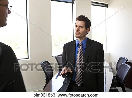 Stock Image - Businessmen talking in office. Fotosearch