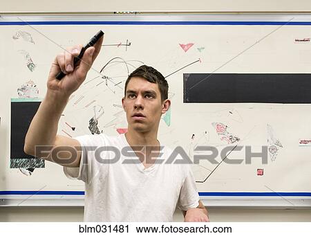 Stock Image - Caucasian artist holding charcoal stick in studio. Fotosearch