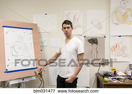 Stock Photo - Caucasian artist standing with sketch in studio. Fotosearch