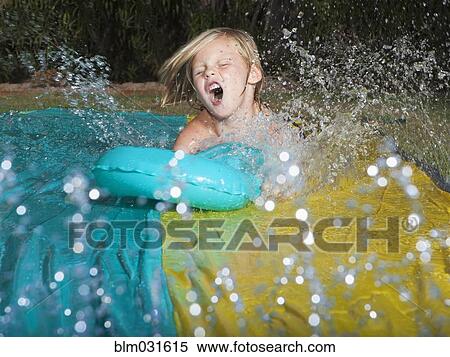 Caucasian boy playing on water slide View Large Photo Image Stock Photography - Caucasian boy playing on water slide. Fotosearch