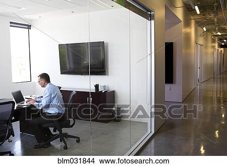 Picture - Caucasian businessman working in office. Fotosearch