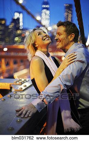 Stock Image - Caucasian couple hugging on Brooklyn Bridge, New York City, New York, United States. Fotosearch