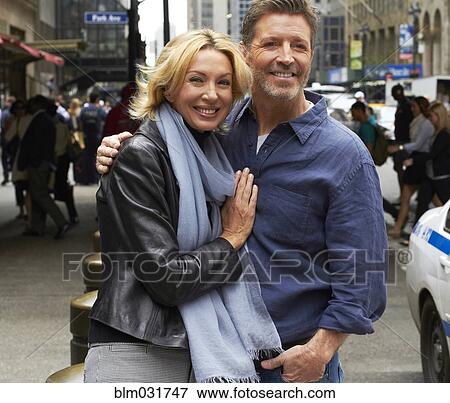 Stock Photo - Caucasian couple hugging on city street, New York City, New York, United States. Fotosearch
