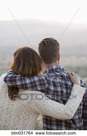 Picture - Caucasian couple hugging outdoors. Fotosearch