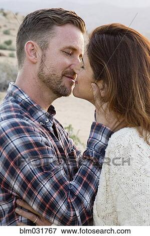 Stock Photo - Caucasian couple kissing outdoors. Fotosearch