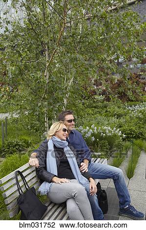 Caucasian couple relaxing on bench in park View Large Photo Image Stock Image - Caucasian couple relaxing on bench in park. Fotosearch