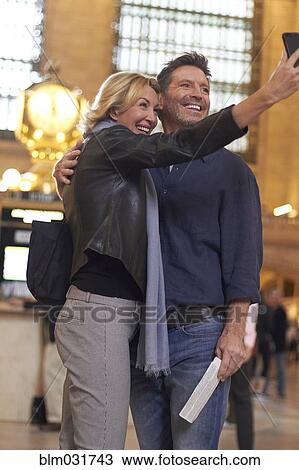 Caucasian couple taking cell phone selfie in Grand Central Station, New York City, New York, United States View Large Photo Image Stock Image - Caucasian couple taking cell phone selfie in Grand Central Station, New York City, New York, United States. Fotosearch