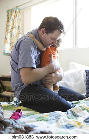 Caucasian father holding daughter on bed View Large Photo Image Stock Image - Caucasian father holding daughter on bed. Fotosearch