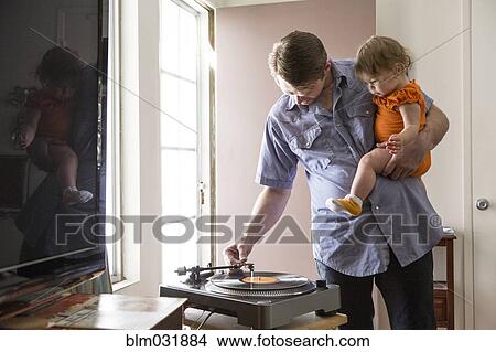 Picture - Caucasian father playing records with daughter. Fotosearch