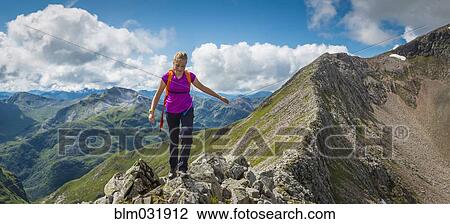 Stock Image - Caucasian girl hiking on rocky mountain. Fotosearch