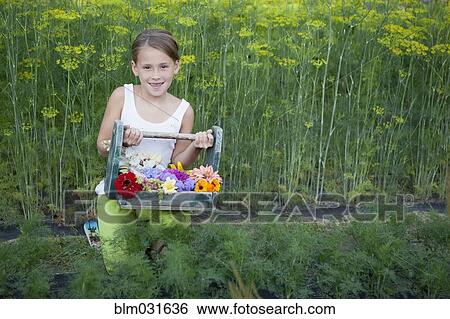 Stock Photograph - Caucasian girl holding basket of flowers. Fotosearch