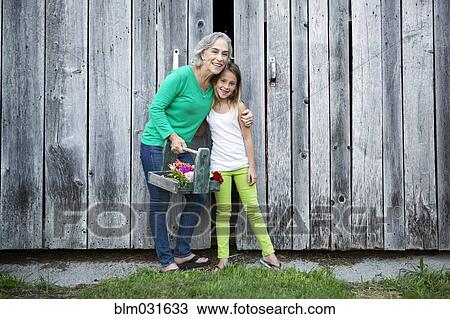 Caucasian grandmother and granddaughter smiling on farm View Large Photo Image Stock Image - Caucasian grandmother and granddaughter smiling on farm. Fotosearch