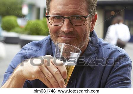 Stock Photo - Caucasian man drinking beer outdoors. Fotosearch