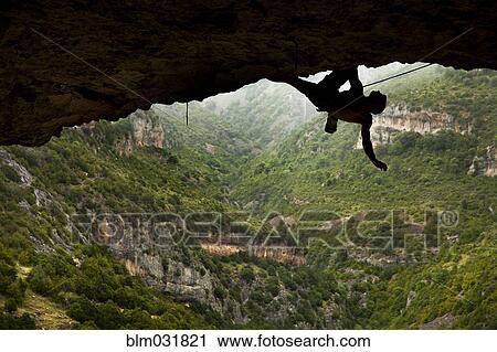 Climber hanging from rock formation View Large Photo Image Stock Image - Climber hanging from rock formation. Fotosearch