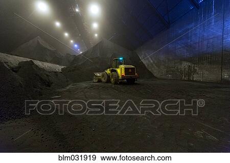 Stock Photo - Digger working in warehouse. Fotosearch