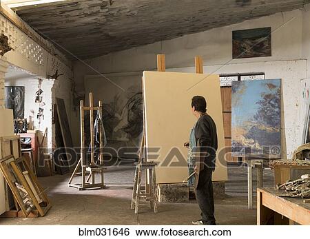 Stock Photograph - Hispanic artist painting in studio. Fotosearch