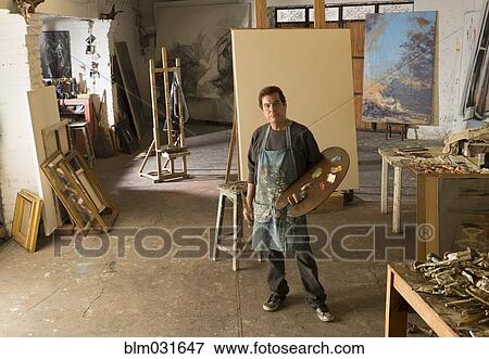 Stock Photo - Hispanic artist standing in studio. Fotosearch