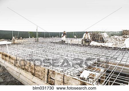 Stock Image - Hispanic construction workers at construction site. Fotosearch