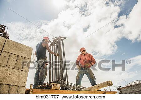 Stock Photo - Hispanic construction workers at construction site. Fotosearch
