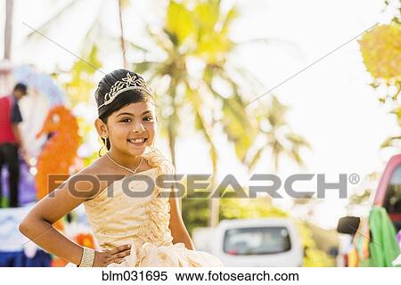 Stock Photography - Hispanic girl posing in ornate dress and tiara. Fotosearch