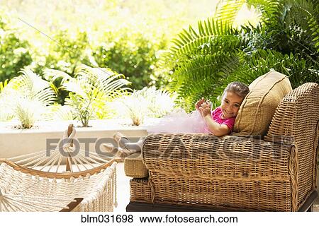 Hispanic girl sitting in armchair outdoors View Large Photo Image Stock Photo - Hispanic girl sitting in armchair outdoors. Fotosearch