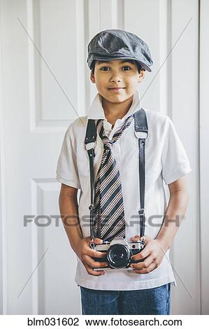 Mixed race boy wearing camera on strap View Large Photo Image Stock Image - Mixed race boy wearing camera on strap. Fotosearch