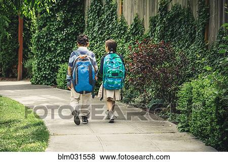 Stock Photo - Mixed race brother and sister walking on sidewalk. Fotosearch