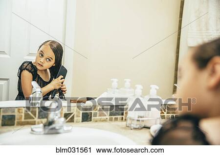 Mixed race girl brushing hair in bathroom View Large Photo Image Stock Image - Mixed race girl brushing hair in bathroom. Fotosearch