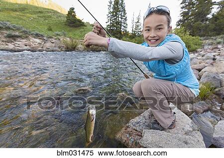 Stock Photography - Mixed race girl fishing in river. Fotosearch