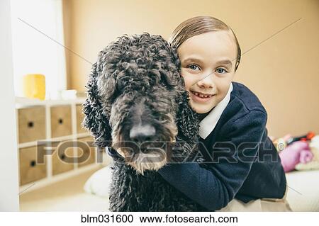 Stock Image - Mixed race girl hugging dog. Fotosearch