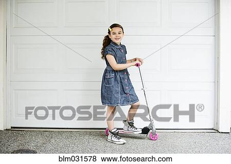 Mixed race girl smiling on scooter in driveway View Large Photo Image Stock Photo - Mixed race girl smiling on scooter in driveway. Fotosearch