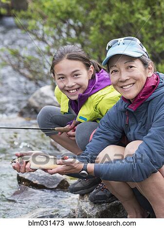 Mother and daughter fishing in river View Large Photo Image Stock Image - Mother and daughter fishing in river. Fotosearch