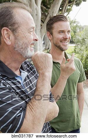 Older Caucasian man relaxing with son outdoors View Large Photo Image Stock Photo - Older Caucasian man relaxing with son outdoors. Fotosearch