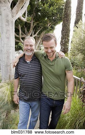Stock Photo - Older Caucasian man walking with son outdoors. Fotosearch