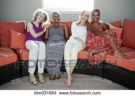 Women relaxing together on urban rooftop View Large Photo Image Picture - Women relaxing together on urban rooftop. Fotosearch