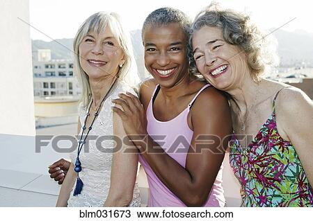Women smiling together on urban rooftop View Large Photo Image Stock Image - Women smiling together on urban rooftop. Fotosearch