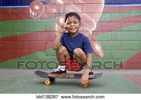 African American boy sitting on skateboard by urban mural View Large Photo Image Stock Photo - African American boy sitting on skateboard by urban mural. Fotosearch