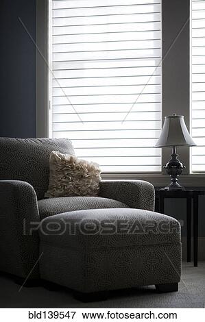 Stock Photo - Armchair and ottoman in modern living room. Fotosearch