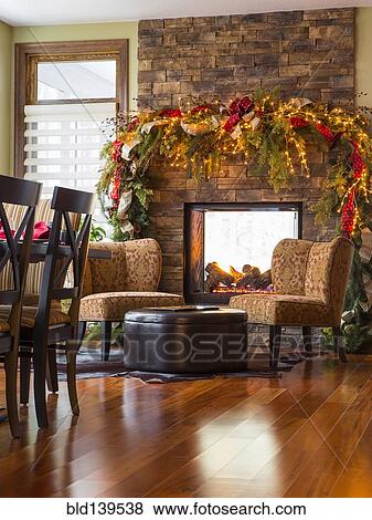 Stock Photo - Armchairs and fireplace in living room at Christmas. Fotosearch