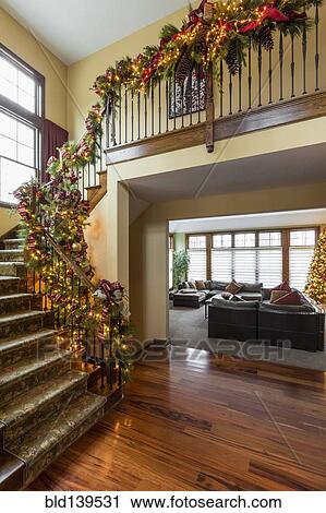 Banister Decorated With Boughs And String Lights For Christmas