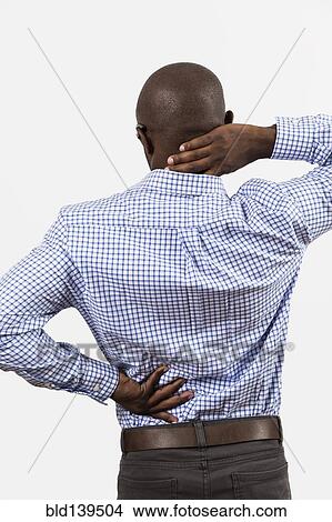 Picture - Black man rubbing aching back and neck. Fotosearch