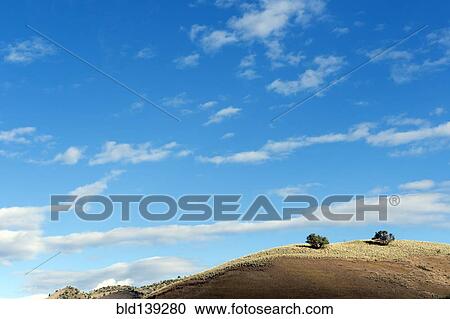 Stock Image - Blue sky over hill. Fotosearch