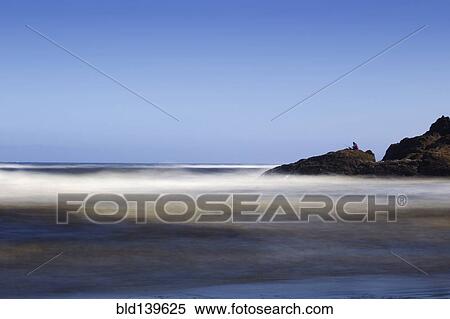 Stock Photography - Blurred waves at rocky beach. Fotosearch