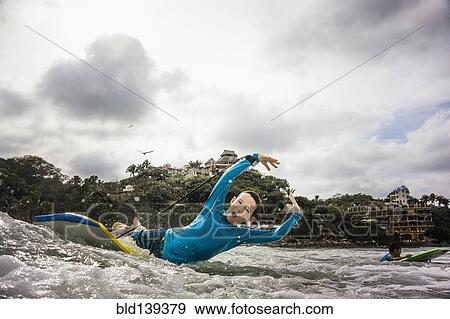 Boys surfing together in waves View Large Photo Image Stock Photo - Boys surfing together in waves. Fotosearch