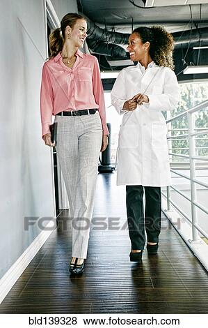 Businesswoman and doctor talking in corridor View Large Photo Image Stock Photo - Businesswoman and doctor talking in corridor. Fotosearch