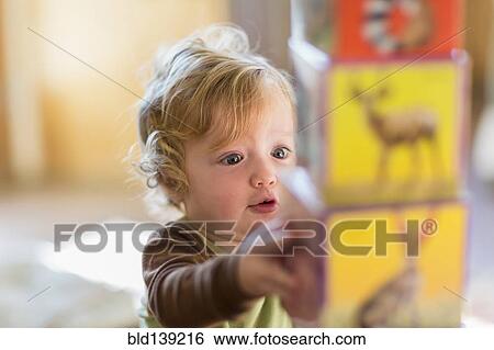 Stock Photograph - Caucasian baby boy stacking colorful blocks. Fotosearch